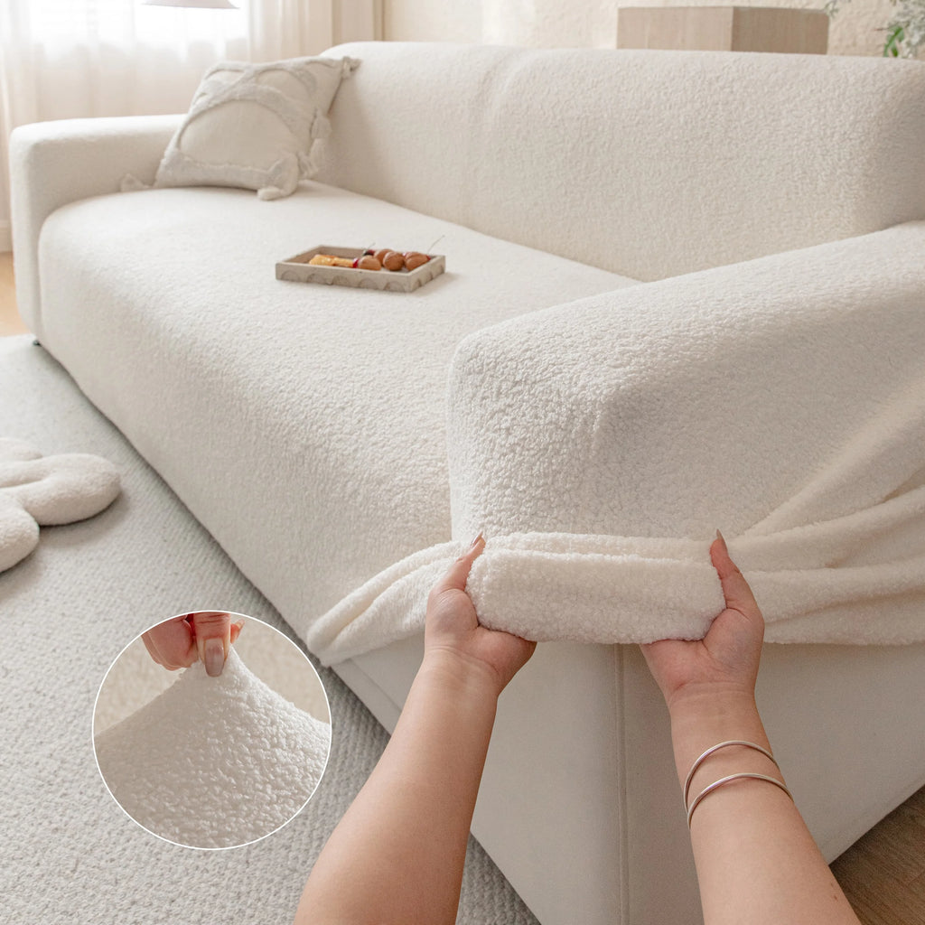 Hands stretching the Teddy Fleece Sofa Cover over a sofa arm